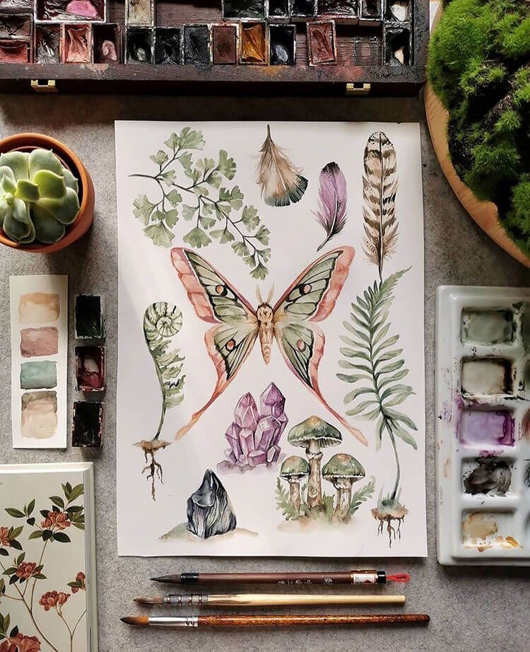 Акварель с бабочкой и растениями на столе художника